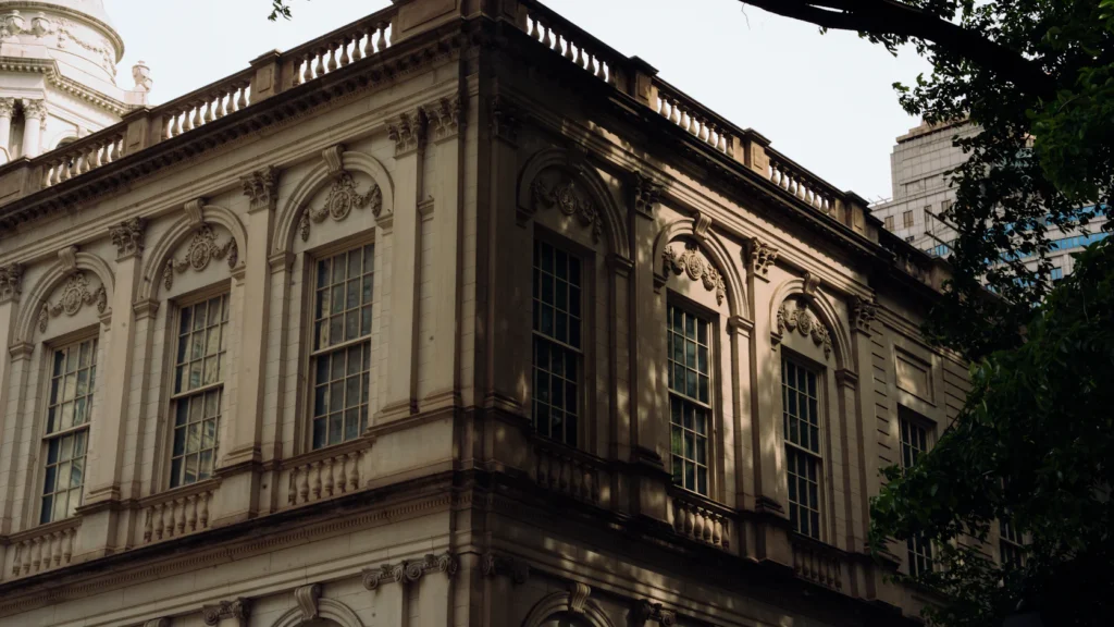 Ornate classical building facade with carved stone details catching the sunlight